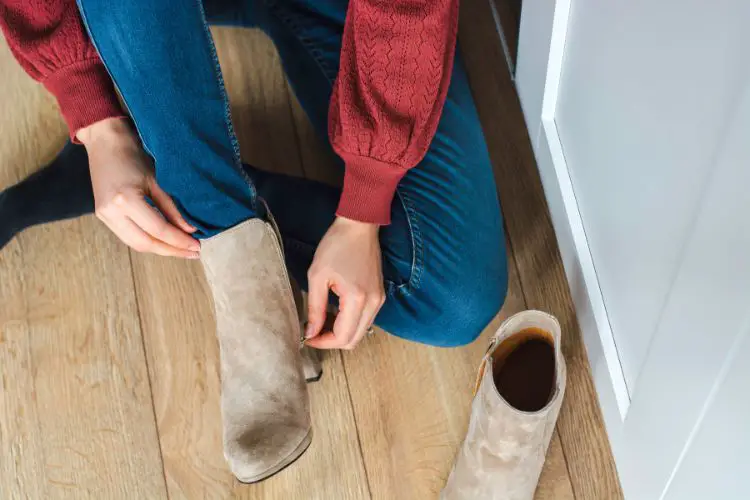 A woman wears jeans with sweater and jeans with suede cowboy boots
