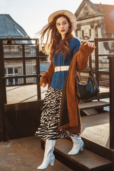 A woman wears midi skirt with sweater coat and shirts