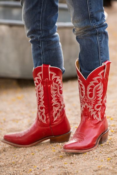 A woman wears red cowboy boots with jeans