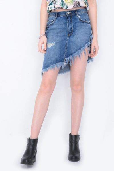 A woman wears ripped denim skirt with black cowgirl boots