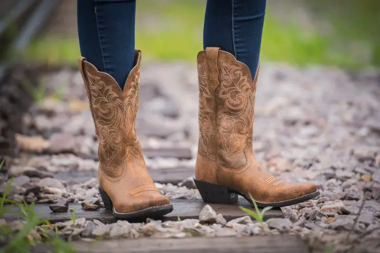 A woman wears skinny jeans with cowboy boots