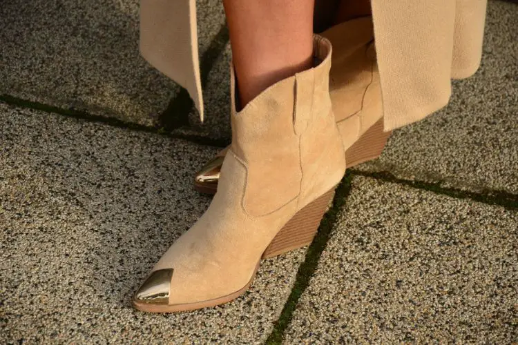 A woman wears slit dress with suede cowboy boots