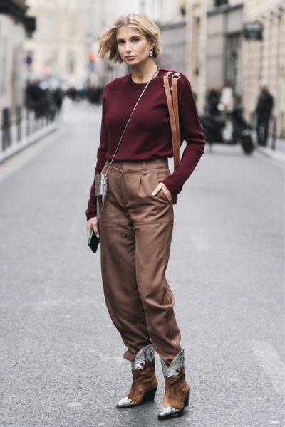 A woman wears street style outfits with cowboy boots