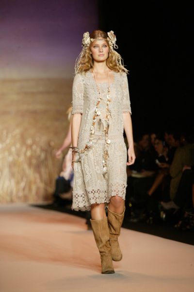A woman wears suede cowboy boots with lace dress