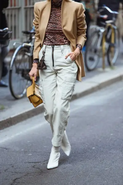 A woman wears trench coat, white cowboy boots, white cargo pants and Leopad t shirt