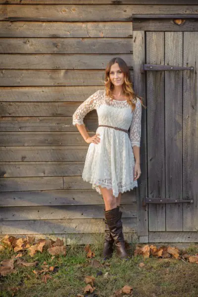 A woman wear lace dress with cowboy boots