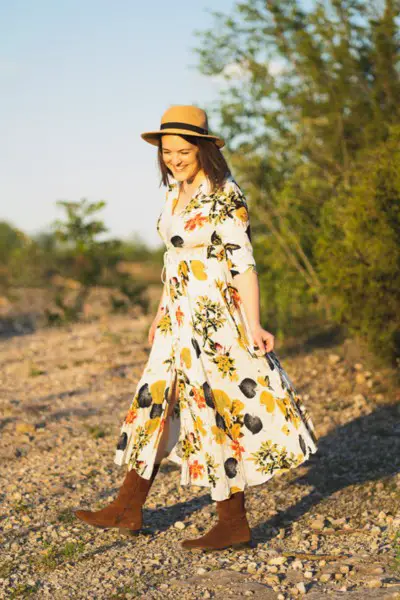 A woman wears floral midi dress with suede cowboy boots