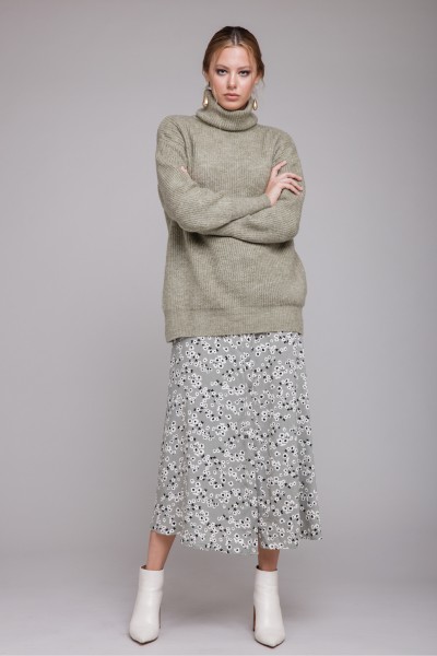 A woman wears floral skirt with sweater