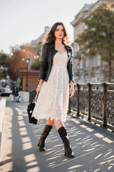 A woman wears lace dress with leather jacket