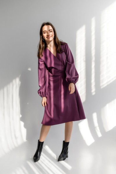 A woman wears purple midi dress with cowboy boots