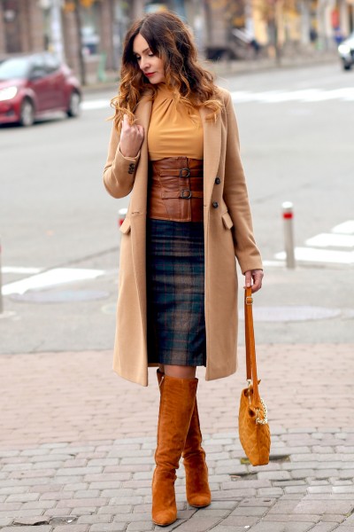 A woman wears skirt, blazer and cowboy boots