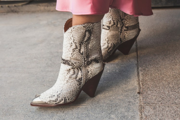 A woman wears snakeskin cowboy boots with pink dress