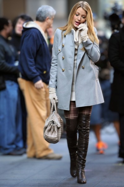 A woman wear turtleneck dress with plaid tights, black cowboy boots and blazer