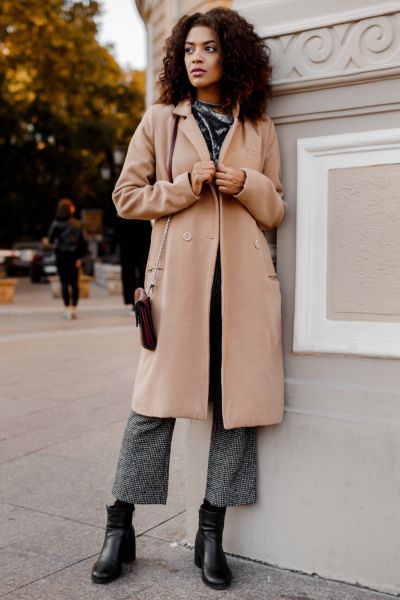 A woman wears black ankle boots with blazer