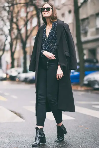 A woman wears black cowboy boots with all black outfit