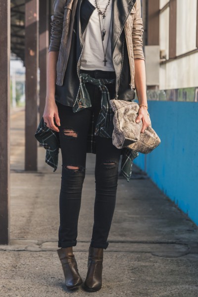 A woman wears black jeans with brown ankle boots for street style
