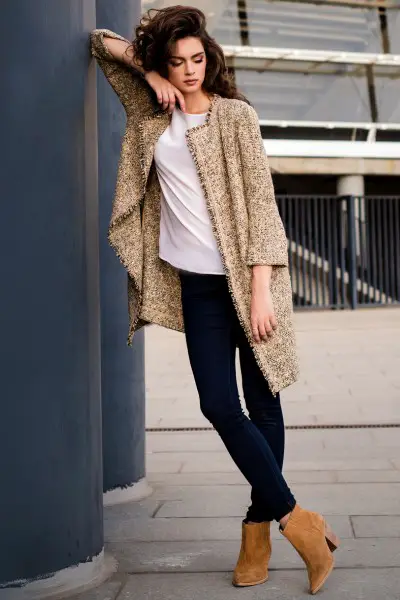 A woman wears coat with skinny jeans, white top and brown cowboy boots