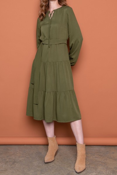 A woman wears green midi dress with brown cowboy boots