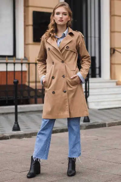 A woman wears jeans, oversize blazer and black cowboy boots