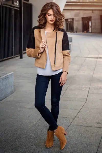 A woman wears leather jacket with ankle suede boots, jeans and leather jacket