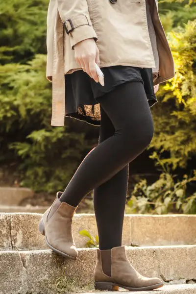 A woman wears leggings with ankle boots