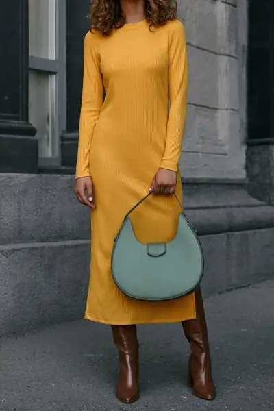 A woman wears long yellow dress with cowboy boots