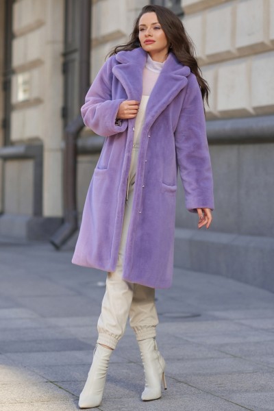A woman wears purple fur coat with white trouser and white cowboy boots