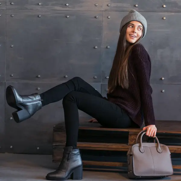 A woman wears sweater, black leggings and black cowboy boots