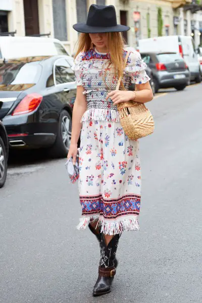 A woman wears vintage dress with cowboy boots