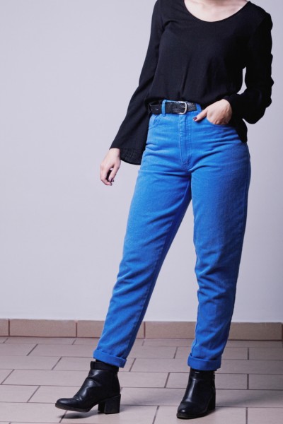 A woman wears black boots, jeans and black blouse