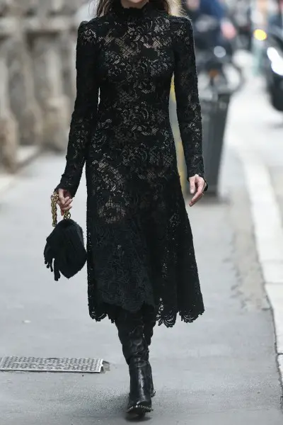 A woman wears black lace dress with cowboy boots