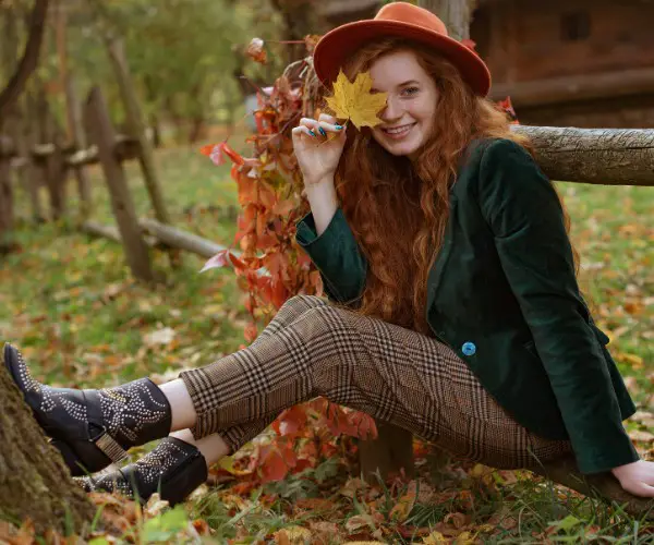 A woman wears black studded cowboy boots with checkered trousers