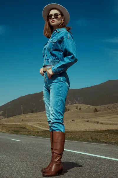 A woman wears denim-on-denim with cowboy boots