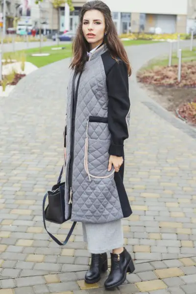 A woman wears dress with trench coat and black cowboy boots