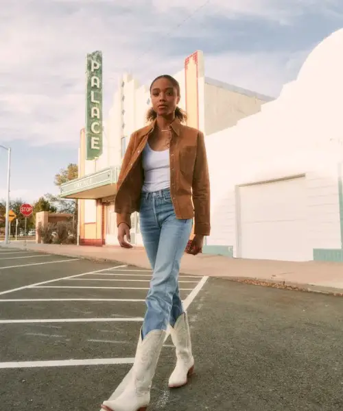 A woman wears jeans, coat, tee and The Annie Boots