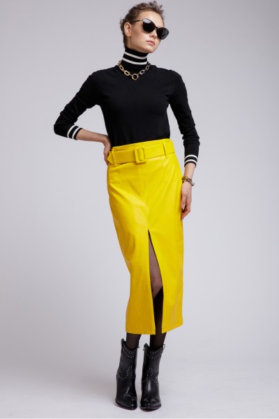 A woman wears mustard skirt with short cowboy boots and black top