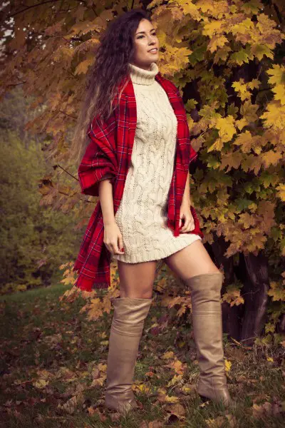 A woman wears red coat, white dress and beige cowboy boots