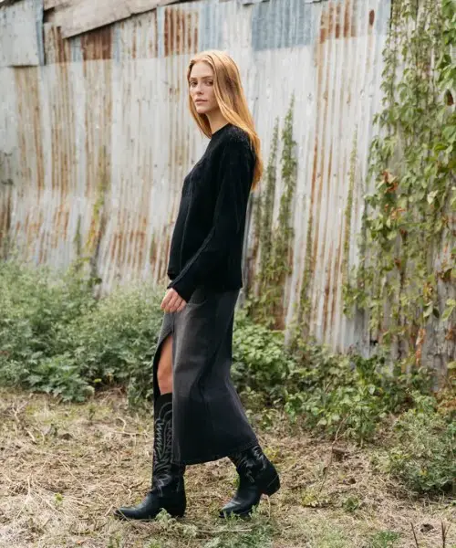 A woman wears split skirt, sweater with The Abby cowboy boots 2