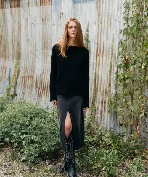 A woman wears split skirt, sweater with The Abby cowboy boots