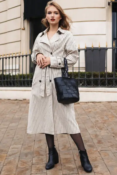 A woman wears stripped dress with tights and cowboy boots