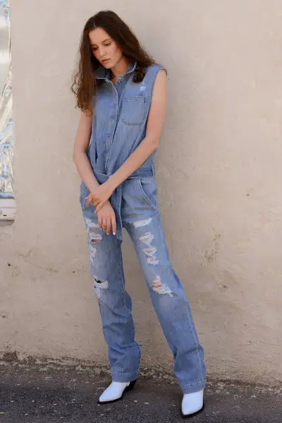 A woman wears white cowboy boots with denim on denim outfit