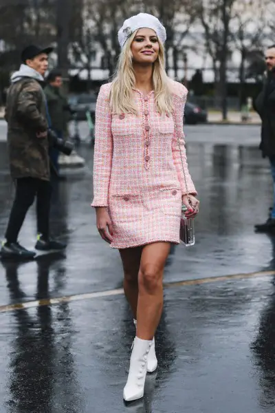 A woman wears white cowboy boots with pink mini dress