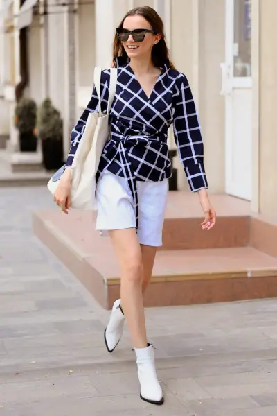 A woman wears white cowboy boots with white shorts and checkered top