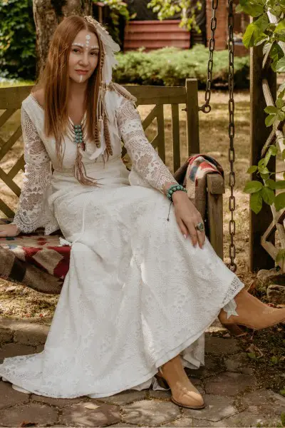 A woman wears white wedding dress with cowboy boots