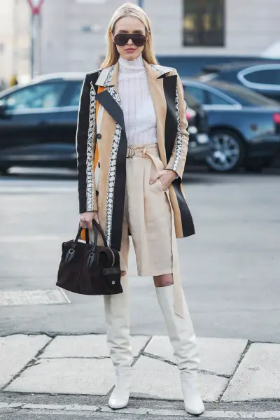 A cool girls wears white cowboy boots with high-rise shorts, turtleneck and textured coat