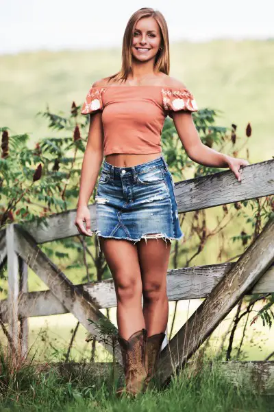 A woman wears a denim skirt with an off shoulder top