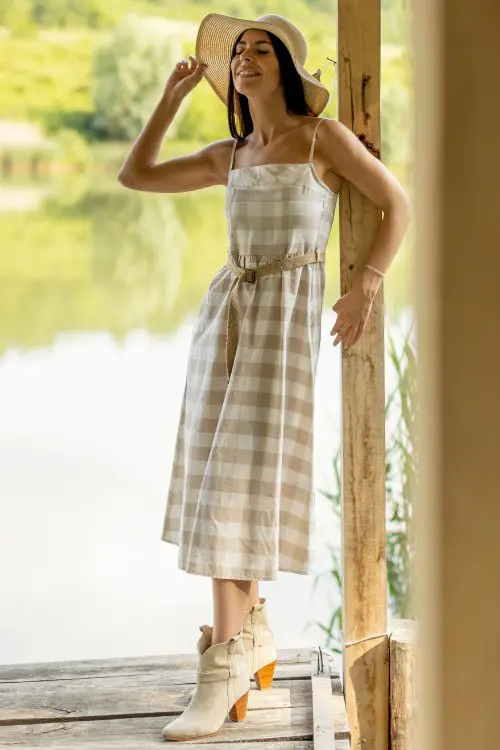 A woman wears ankle cowboy boots with a long dress