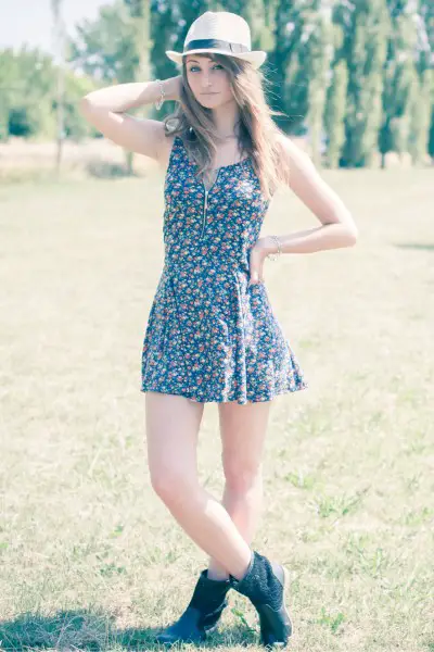 A woman wears black ankle cowboy boots with floral dress