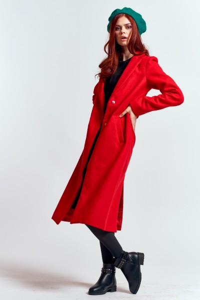 A woman wears black ankle cowboy boots with red long coat