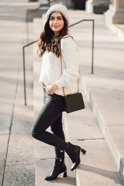 A woman wears black jeans with black ankle cowboy boots